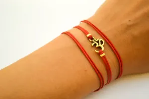 Wrapped red bracelet with gold tone Om charm, yoga jewelry for her